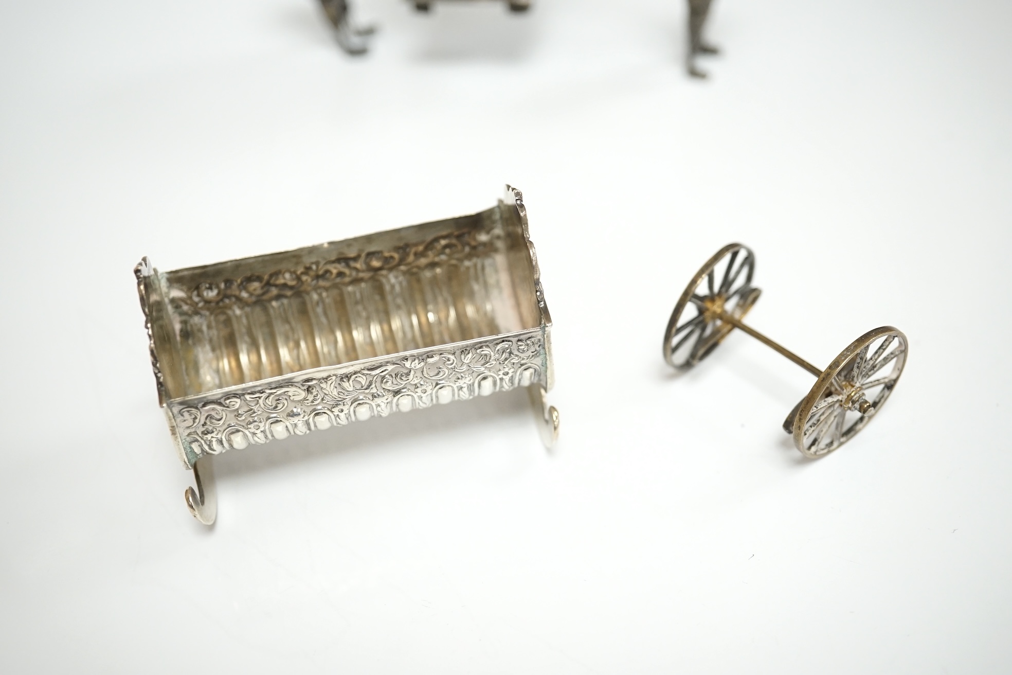 A small collection of miniature silver and white metal items including a cot by Saunders & Shepherd, Birmingham, 1896, 57mm, two filigree items, two Kiddush cups etc. Condition - poor to fair